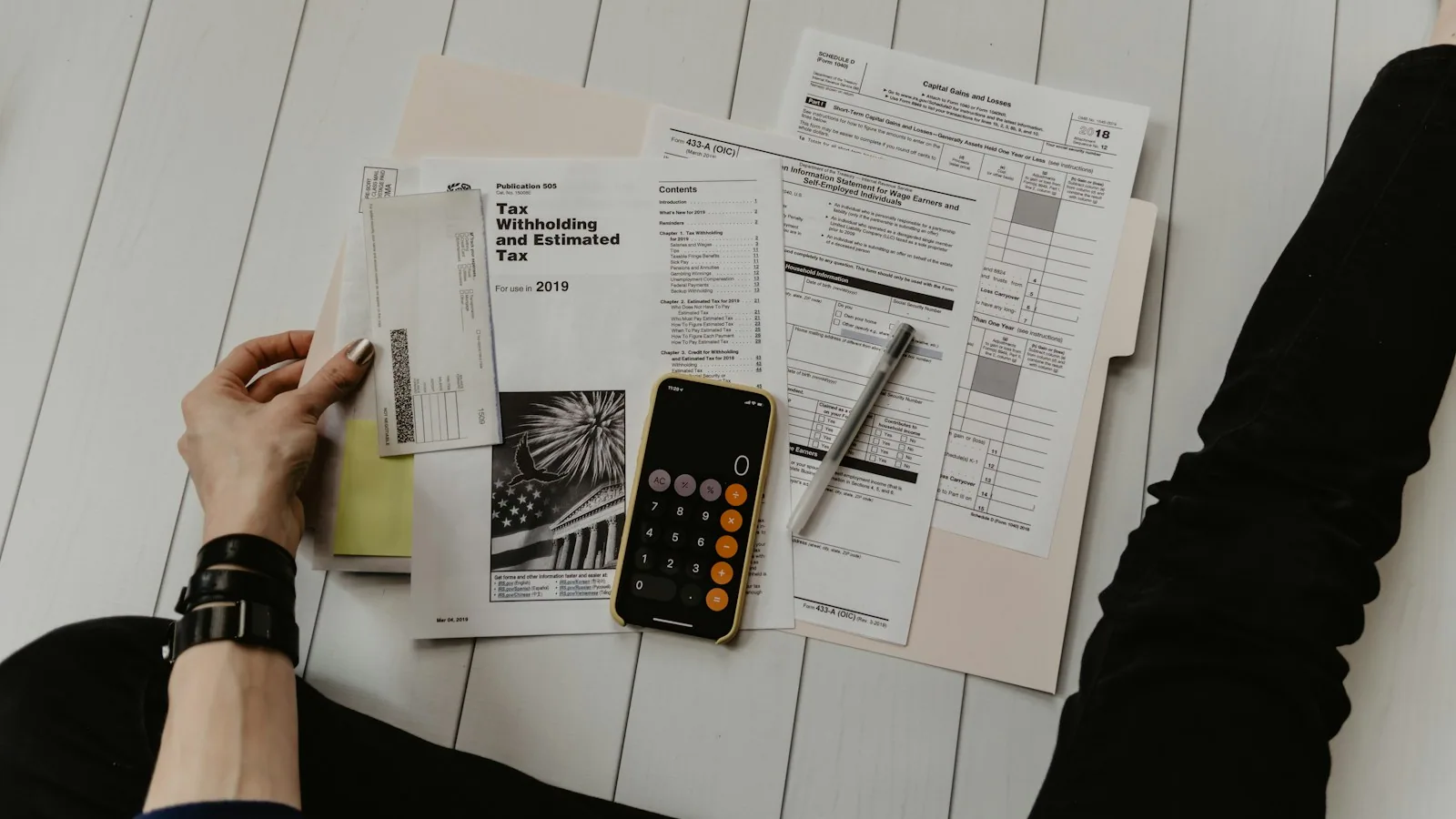 Calculator, pen and property paperwork laid out on a desk