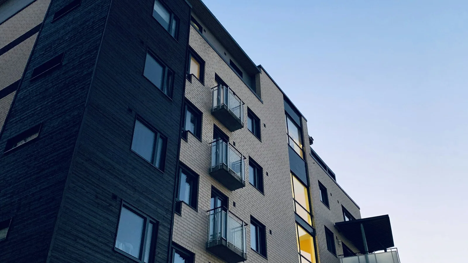 Modern residential tower facade under blue sky