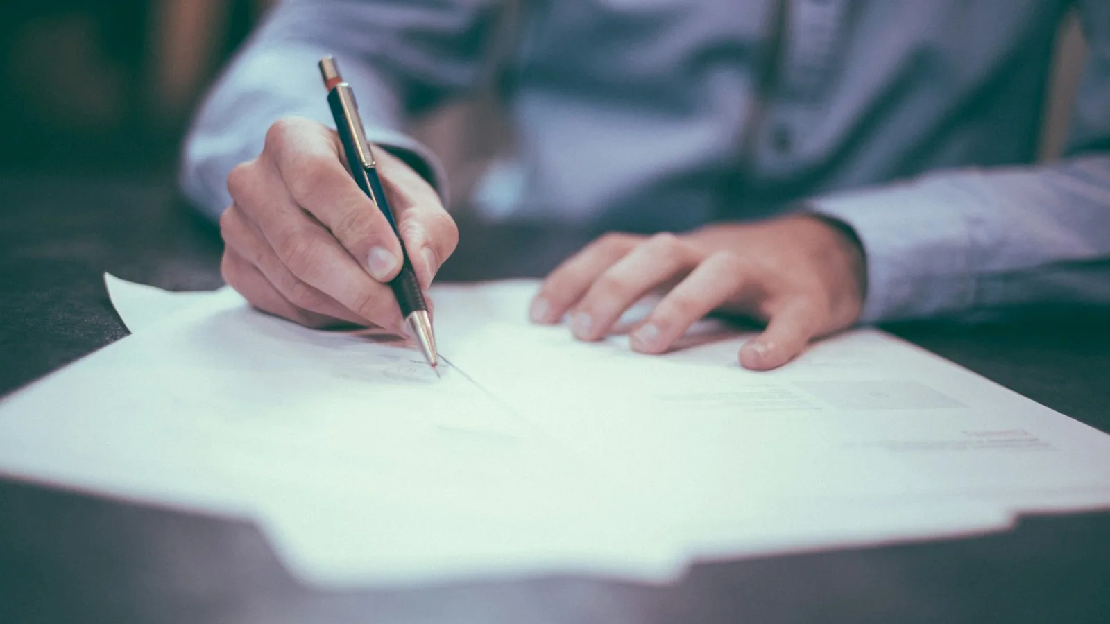 Mortgage paperwork with pen and reading glasses on a desk